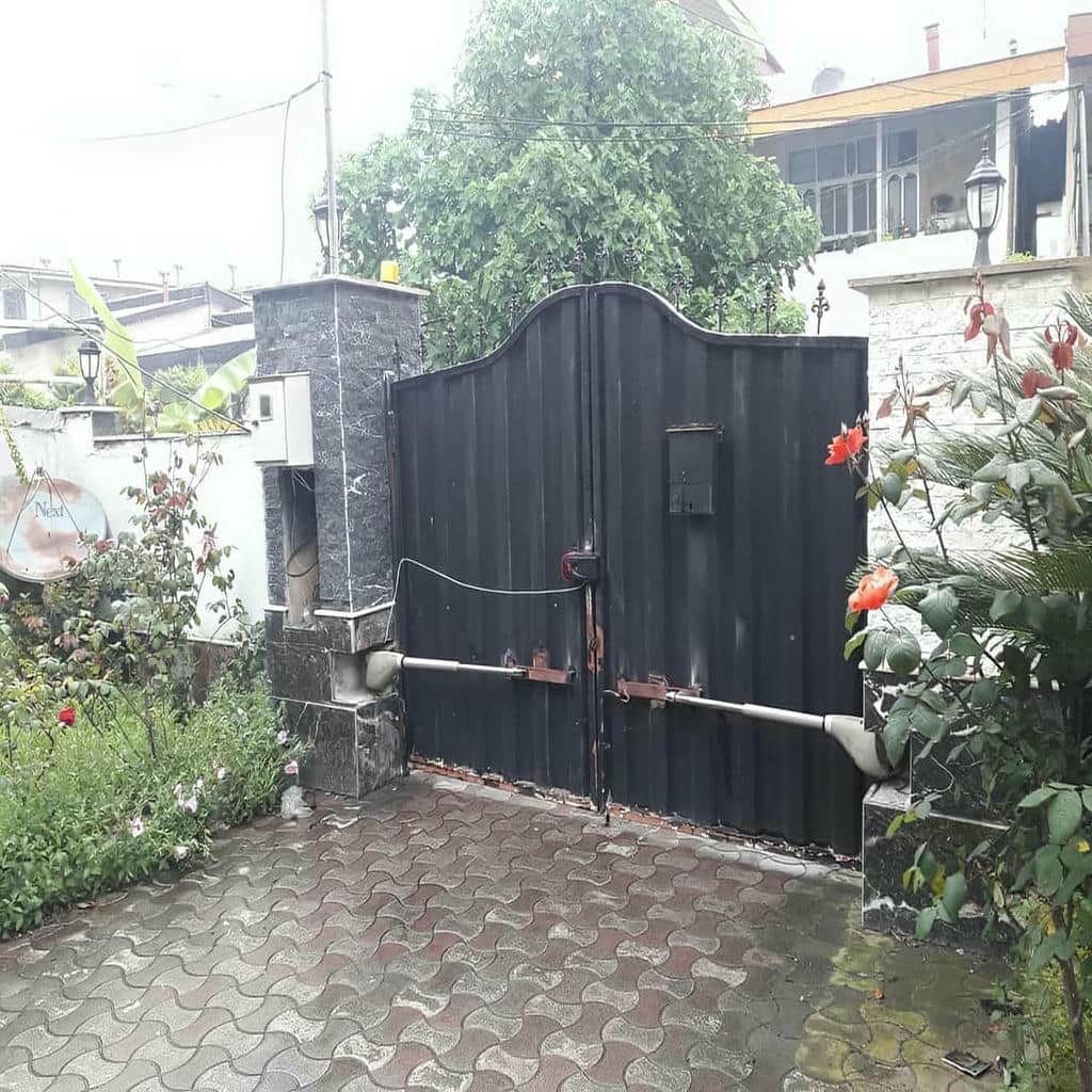 جک بازویی نقره‌ای روی درب آهنی در استان کرمانشاه