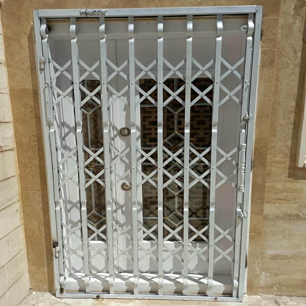 حفاظ درب آکاردئونی مشکی کنار درب چوبی