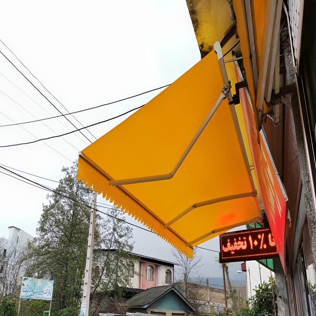 سایبان برقی بازشده روی تراس با پارچه طوسی