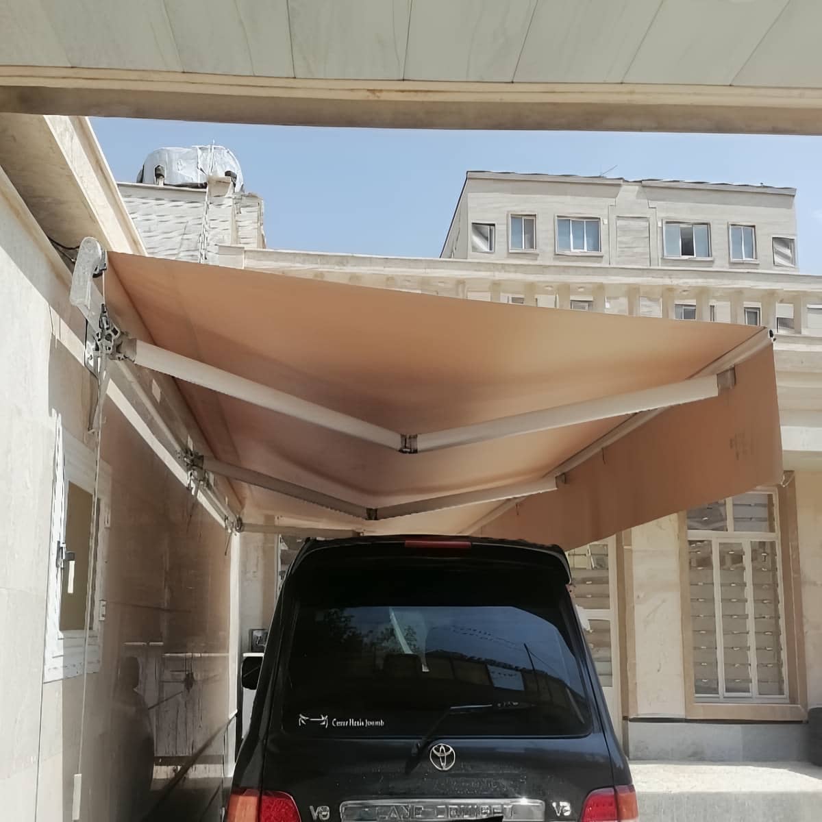 سایبان برقی بازویی کرم در نمای فروشگاه ایلام