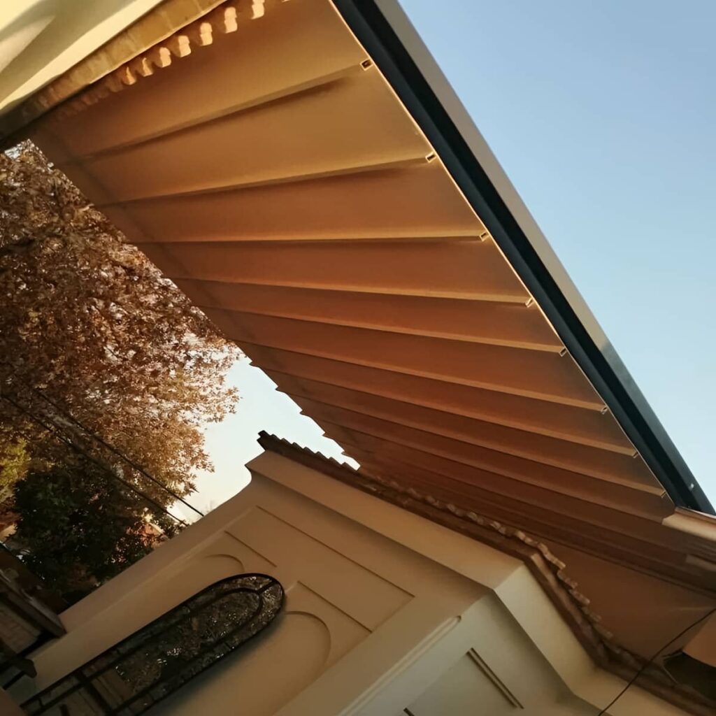 سایبان برقی جمع شده کنار نمای آجری ساختمان سایبان برقی جمع شده کنار نمای آجری ساختمان