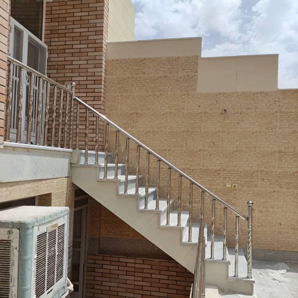 نرده راه پله استیل کنار پله سنگی روشن